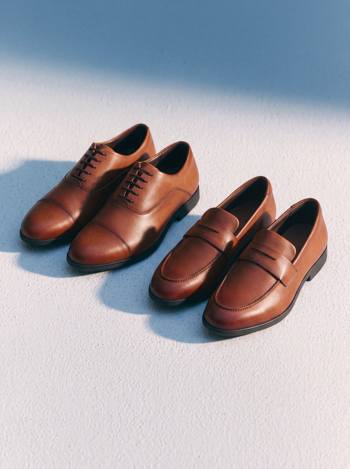 Capital Oxford and Capital Loafer in whiskey, side by side in the sun