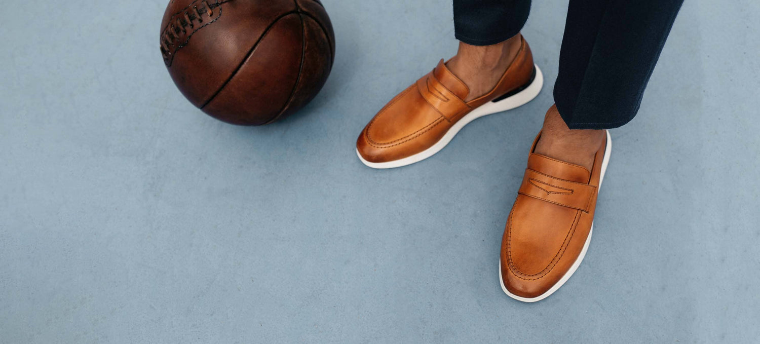 Knee down view of man with basketball wearing Crossover Loafer shoe in Honey