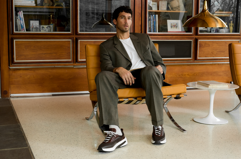 Model in a leather lounge chair wearing SuperCrossover Trainers