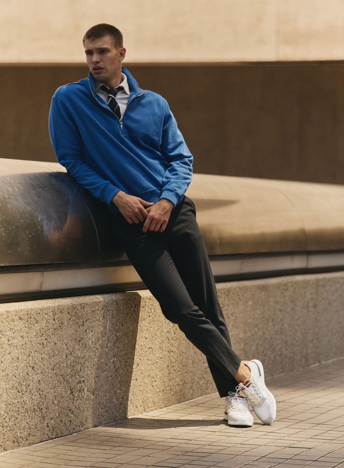 Crossover Victory Trainer in White, worn with a blue quarter-zip